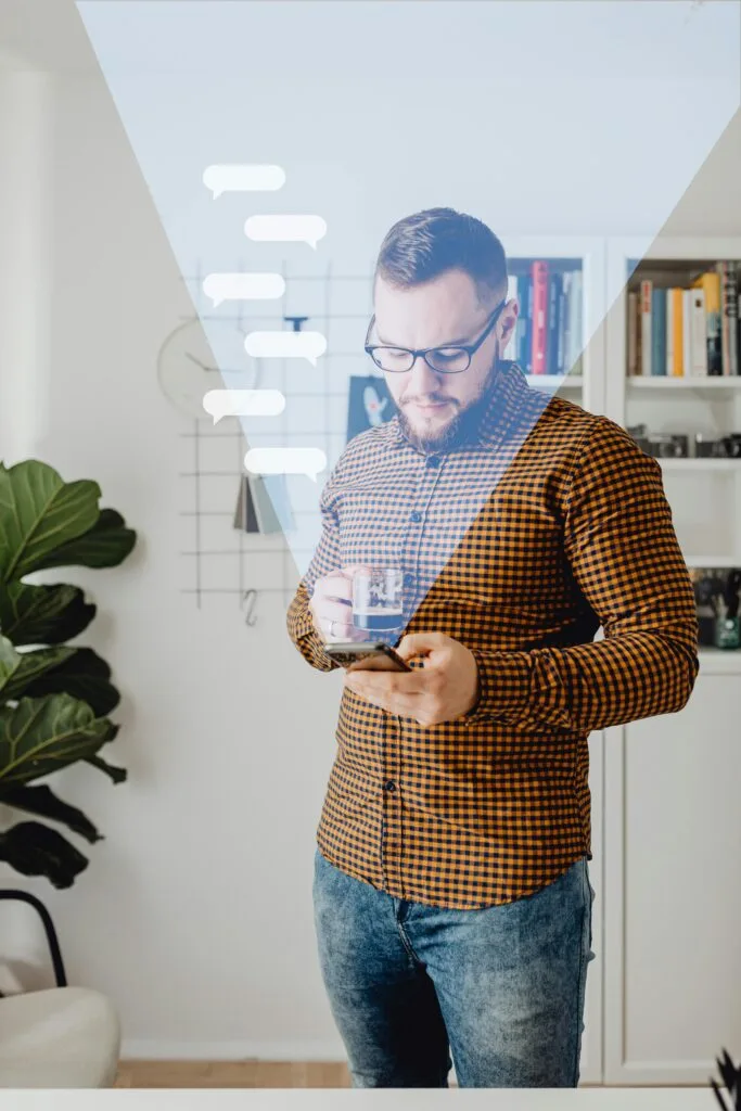 pexels-photo-6214835-6214835 A man in casual attire using a smartphone, standing in a modern home office with overlay graphics.